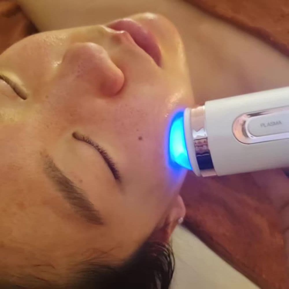 Plasma head on a client's cheek during a salon facial