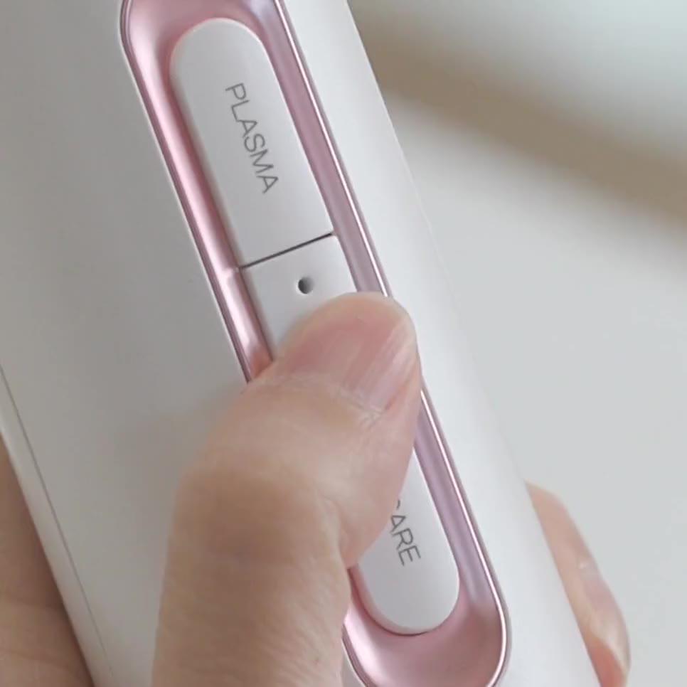 A thumb presses the button between the Plasma and Skincare labels; its small light comes on
